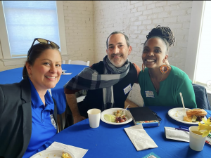 Photos of faculty and community partners around a table with blue tablecloths.